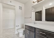 Thumbnail 56 of 68 - A bathroom with a toilet, sink, and mirror.