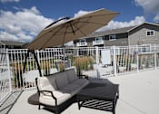 Thumbnail 40 of 46 - A patio with a couch and umbrella.