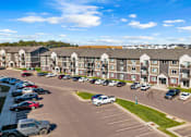 Thumbnail 45 of 59 - A parking lot in front of apartment buildings.