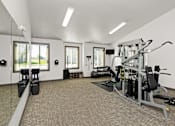 Thumbnail 25 of 37 - A well-equipped gym with a variety of machines and weightlifting equipment.
