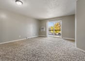 Thumbnail 19 of 41 - A room with a carpeted floor and a sliding glass door leading outside.