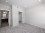 Thumbnail 18 of 32 - A large empty room with a carpeted floor and white walls.