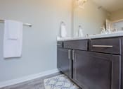 Thumbnail 24 of 29 - a bathroom with a sink and a mirror and a towel rack