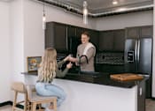 Thumbnail 59 of 73 - A man is serving a woman at a bar.
