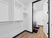 Thumbnail 73 of 73 - A white hallway with a black door and a black mat on the floor.