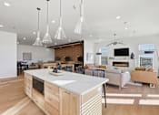 Thumbnail 65 of 68 - A modern kitchen with a white island and wooden floors.
