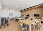 Thumbnail 58 of 68 - A modern dining room with a long wooden table and chairs.
