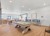 Thumbnail 5 of 68 - A billiard table is in the middle of a room with a white wall and a door.