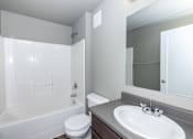 Thumbnail 62 of 81 - A white bathroom with a toilet, sink, and bathtub.