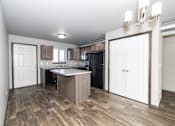 Thumbnail 65 of 81 - A kitchen with a white door and a wooden floor.