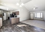 Thumbnail 3 of 37 - A spacious living room with a kitchen area in the background.