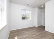 Thumbnail 11 of 16 - A room with a window and a wooden floor.