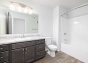 Thumbnail 13 of 16 - A bathroom with a white toilet and a marble counter.