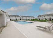 Thumbnail 17 of 53 - A swimming pool in a residential area with a bench and a fence.