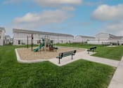 Thumbnail 20 of 53 - A playground with a green slide and two benches.