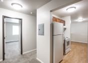 Thumbnail 10 of 15 - a room with a refrigerator and a stove and a door to a kitchen