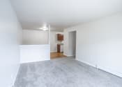 Thumbnail 8 of 15 - an empty living room with a white wall and carpet