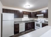 Thumbnail 5 of 15 - a kitchen with white appliances and dark wood cabinets