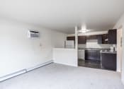 Thumbnail 2 of 15 - an empty living room with a kitchen in the background