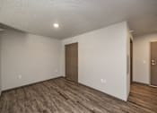 Thumbnail 27 of 45 - A room with wooden floors and two brown doors.