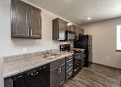 Thumbnail 28 of 45 - A kitchen with black appliances and cabinets.