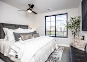 Thumbnail 5 of 41 - A bedroom with a large bed and a window overlooking a cityscape.