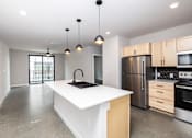 Thumbnail 11 of 41 - A modern kitchen with a white island and stainless steel appliances.