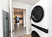Thumbnail 19 of 41 - A white washing machine is in a kitchen.