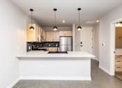 Thumbnail 16 of 41 - A modern kitchen with a large island in the middle.