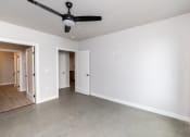 Thumbnail 10 of 41 - a living room with white walls and a ceiling fan