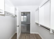 Thumbnail 6 of 41 - a walk in closet with white cabinets and a window