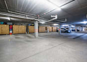 Thumbnail 13 of 27 - A parking garage with a concrete floor and a concrete ceiling with lights.