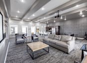 Thumbnail 31 of 46 - A modern living room with grey carpeting and furniture.