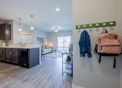Thumbnail 12 of 29 - a kitchen and living room with a backpack on the wall