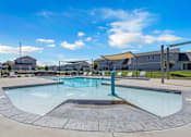 Thumbnail 41 of 81 - A large outdoor swimming pool with a diving board and lounge chairs.