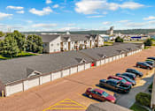Thumbnail 35 of 40 - A parking lot with cars and a building in the background.