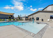 Thumbnail 46 of 81 - A large outdoor swimming pool with a diving board and lounge chairs.