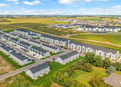 Thumbnail 54 of 58 - A large, modern housing complex with multiple buildings and a spacious lawn area.
