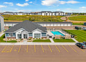 Thumbnail 58 of 58 - A parking lot with a building and a pool in the background.