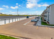 Thumbnail 57 of 58 - A parking lot with a few cars and a building in the background.