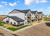 Thumbnail 40 of 44 - A large building with a parking lot in front of it.