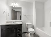 Thumbnail 19 of 31 - A white bathroom with a toilet, sink, and bathtub.