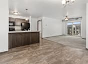 Thumbnail 11 of 31 - A kitchen with a wooden floor and a white wall.