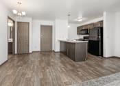 Thumbnail 4 of 31 - A kitchen with a black refrigerator and wooden floors.