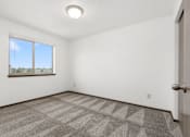 Thumbnail 20 of 31 - A room with a carpeted floor and a window.
