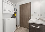 Thumbnail 24 of 31 - A small bathroom with a washer and dryer built into the cabinetry.
