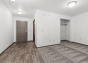 Thumbnail 23 of 31 - A room with a wooden floor and a brown door.