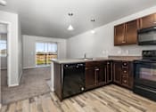 Thumbnail 16 of 26 - A kitchen with black appliances and wooden cabinets.