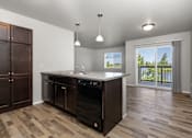 Thumbnail 17 of 26 - A kitchen with a black dishwasher and wooden cabinets.