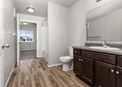 Thumbnail 18 of 26 - A bathroom with a toilet, sink, and wooden floors.